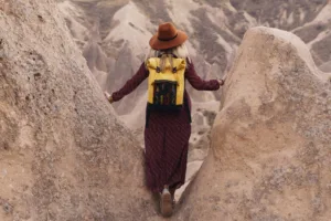 Woman-with-backpack-walking-through-rock-formations-in-Cappadocia